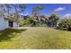 Spacious backyard with grassy lawn and mature trees at 20340 Zelda Ave, Port Charlotte, FL 33952