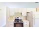 Modern kitchen with white cabinets and a sleek stovetop at 20340 Zelda Ave, Port Charlotte, FL 33952