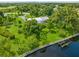 Aerial view of a single-story home with a large yard and private dock on the water at 8516 Riverside Dr, Punta Gorda, FL 33982