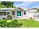 House exterior featuring a teal door and landscaped yard at 8516 Riverside Dr, Punta Gorda, FL 33982