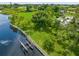 Aerial view showcasing a waterfront property with a home, dock and lush green space at 8516 Riverside Dr, Punta Gorda, FL 33982