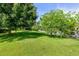 Landscaped backyard with lush green grass and mature trees at 8516 Riverside Dr, Punta Gorda, FL 33982