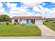 Charming single-story home with a teal door at 5104 Chaves Cir, Port Charlotte, FL 33948
