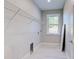Functional laundry room with shelving, window, and vinyl plank flooring at 2239 Cornelius Blvd, Port Charlotte, FL 33953