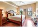 Main bedroom with wood post bed, hardwood floors, and large windows at 96 Vivante Blvd # 96211, Punta Gorda, FL 33950