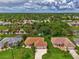 Wide aerial view of a residential neighborhood with houses, palm trees, and a canal at 1112 W Hillsborough Blvd, North Port, FL 34288