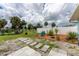 Lush backyard with tropical palm trees, concrete paver accents, and a privacy fence at 7456 Jennifer Dr, Port Charlotte, FL 33981