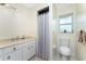 A cozy bathroom featuring a vanity with storage and a shower with a neutral pattern curtain at 7456 Jennifer Dr, Port Charlotte, FL 33981