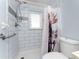 Bathroom featuring tiled walls, a modern grab bar and a charming moose-themed shower curtain at 7456 Jennifer Dr, Port Charlotte, FL 33981