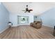 Cozy living room featuring a large window, wood-look floors, and a comfortable leather couch at 7456 Jennifer Dr, Port Charlotte, FL 33981
