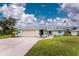 Front view of a charming light blue single-story house with a neatly landscaped lawn at 7456 Jennifer Dr, Port Charlotte, FL 33981