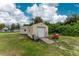 Tan storage shed with roll-up door and adjacent wheelbarrow at 7456 Jennifer Dr, Port Charlotte, FL 33981