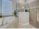 Bathroom featuring a soaking tub, walk-in shower, and tiled walls at 15240 Spanish Point Dr, Port Charlotte, FL 33981