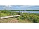 Private wooden dock with a boat lift overlooking a peaceful waterway and lush vegetation at 15240 Spanish Point Dr, Port Charlotte, FL 33981