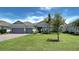 Attractive single-story home featuring a well-kept lawn, paver driveway, and inviting entryway at 15240 Spanish Point Dr, Port Charlotte, FL 33981