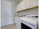Laundry room with white washer and dryer, granite counter, and overhead cabinets at 15240 Spanish Point Dr, Port Charlotte, FL 33981