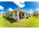 Tan house with covered patio, landscaping, and AC unit at 8883 Tuscany Isles Dr, Punta Gorda, FL 33950