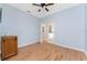 Bright bedroom with light blue walls, wood-look floors, and access to bathroom at 8883 Tuscany Isles Dr, Punta Gorda, FL 33950