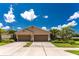 Two-car garage twin villa with a well-maintained lawn and tropical plants at 8883 Tuscany Isles Dr, Punta Gorda, FL 33950