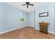 Spacious bedroom with light blue walls, wood-look floors, and ceiling fan at 8883 Tuscany Isles Dr, Punta Gorda, FL 33950