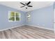 Bedroom with light blue walls, wood-look floors, ceiling fan and lake view at 8883 Tuscany Isles Dr, Punta Gorda, FL 33950