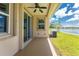 Covered patio overlooking a lake, featuring sliding glass doors and ceiling fan at 8883 Tuscany Isles Dr, Punta Gorda, FL 33950