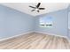 Bedroom with light blue walls, wood-look floors, ceiling fan and lake view at 8883 Tuscany Isles Dr, Punta Gorda, FL 33950