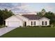 New construction ranch style home with a two-car garage, landscaping, and a neutral color palette at 10459 Calumet Blvd, Port Charlotte, FL 33981