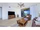 Bright living room featuring hardwood floors, large TV, and access to balcony with water views at 85 Vivante Blvd # 8524, Punta Gorda, FL 33950