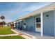 Updated home with covered porch and two chairs, freshly painted blue brick exterior at 8724 Agress Ave, North Port, FL 34287