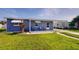 Charming bungalow with freshly painted blue exterior, new landscaping, and covered porch at 8724 Agress Ave, North Port, FL 34287