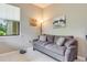 Small office with gray couch, floor lamp, and window at 2555 Brassica Dr, North Port, FL 34289
