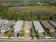 Row of houses with tile roofs, lush landscaping, and a view of a lake at 2555 Brassica Dr, North Port, FL 34289