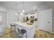 Modern kitchen boasts white cabinets, stainless steel appliances, and a large quartz island at 725 Essex Ave, Port Charlotte, FL 33948