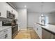 Open concept kitchen with white cabinets and stainless steel appliances at 725 Essex Ave, Port Charlotte, FL 33948