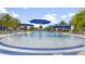 Circular pool with blue umbrellas and lounge chairs at 13948 Miranese St, Venice, FL 34293