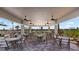 Covered patio area with multiple tables and chairs near the pool at 13948 Miranese St, Venice, FL 34293