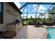 Outdoor kitchen and dining area next to the pool at 13948 Miranese St, Venice, FL 34293