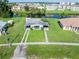 Aerial view of property featuring lush lawn, mature trees, and charming single-story home at 3107 Easy St, Port Charlotte, FL 33952