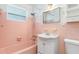 A full bathroom with a tub and shower combo, decorative sink and pink tiling at 3107 Easy St, Port Charlotte, FL 33952