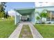 Exterior featuring a driveway, covered parking, a palm tree, and tropical foliage at 3107 Easy St, Port Charlotte, FL 33952