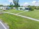 Desirable home with a green lawn, mature landscaping, and covered parking at 3107 Easy St, Port Charlotte, FL 33952
