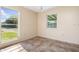 Sunny room with neutral walls, tile floors, and windows overlooking the outdoors at 3107 Easy St, Port Charlotte, FL 33952