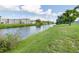 Scenic view of a tranquil river with lush green banks and a neighborhood in the background at 3107 Easy St, Port Charlotte, FL 33952