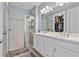 Elegant bathroom with double vanity, large mirror, and walk-in shower at 43614 Sparrow Dr, Punta Gorda, FL 33982
