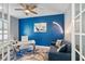 Home office with desk, seating area, and blue accent wall at 43614 Sparrow Dr, Punta Gorda, FL 33982