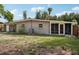 Rear view of house with screened porch and yard at 1642 Banyan Dr, Venice, FL 34293