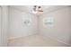 Well-lit bedroom featuring ceiling fan and two windows at 1642 Banyan Dr, Venice, FL 34293