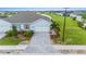 Front view of a light blue house with a paved driveway and landscaped yard at 1781 W Palms Dr, Port Charlotte, FL 33953