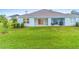 Large backyard with grassy lawn and a covered patio at 1781 W Palms Dr, Port Charlotte, FL 33953